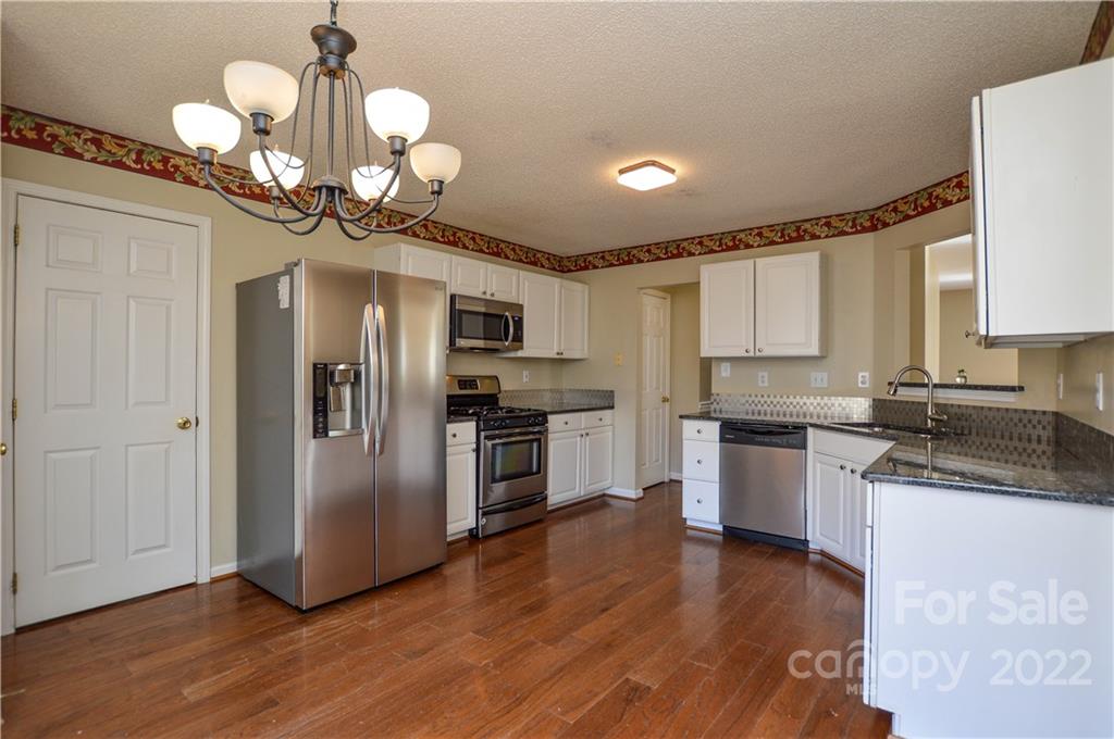 7608 Henderson Park Road Huntersville, NC 28078 - Photo 13 of 39 a kitchen with stainless steel appliances granite countertop a refrigerator a stove a sink and a microwave
