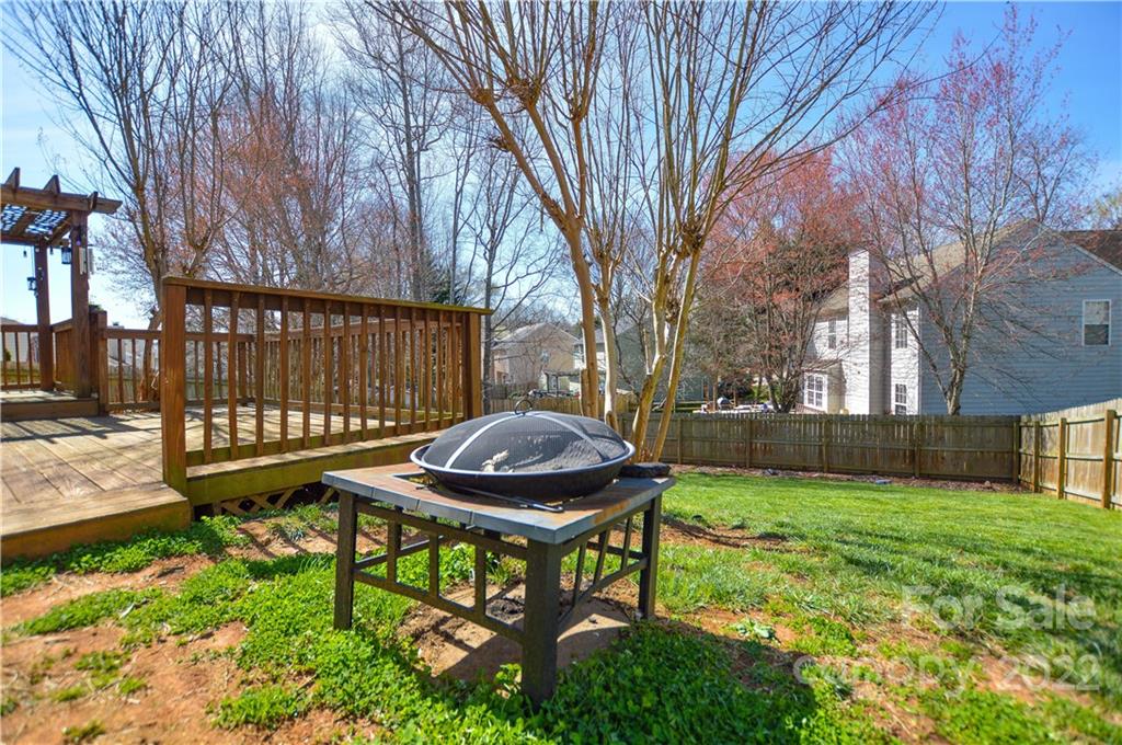 7608 Henderson Park Road Huntersville, NC 28078 - Photo 33 of 39 a view of a backyard with table and chairs and a barbeque with potted plants and large trees