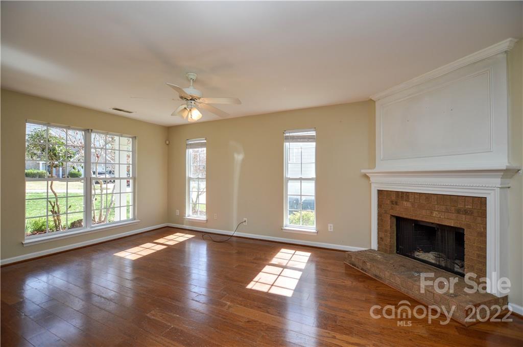 7608 Henderson Park Road Huntersville, NC 28078 - Photo 8 of 39 an empty room with windows fireplace and wooden floor