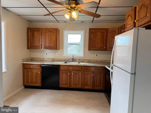 a kitchen with stainless steel appliances granite countertop a refrigerator a sink and dishwasher