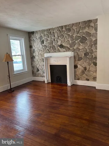 wooden floor fireplace and windows in an empty room