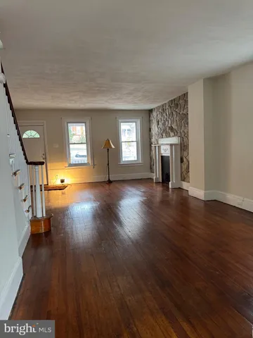 a view of a livingroom with wooden floor and a fireplace