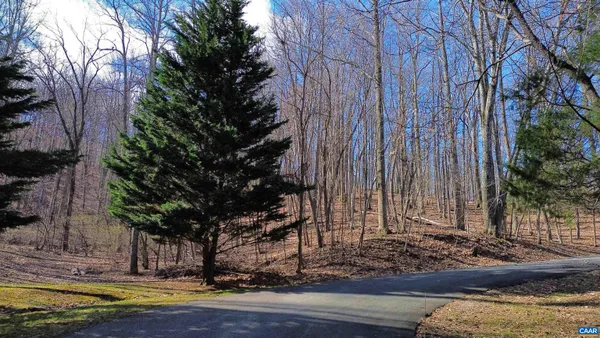 a view of a house with a yard tree and wooden fence