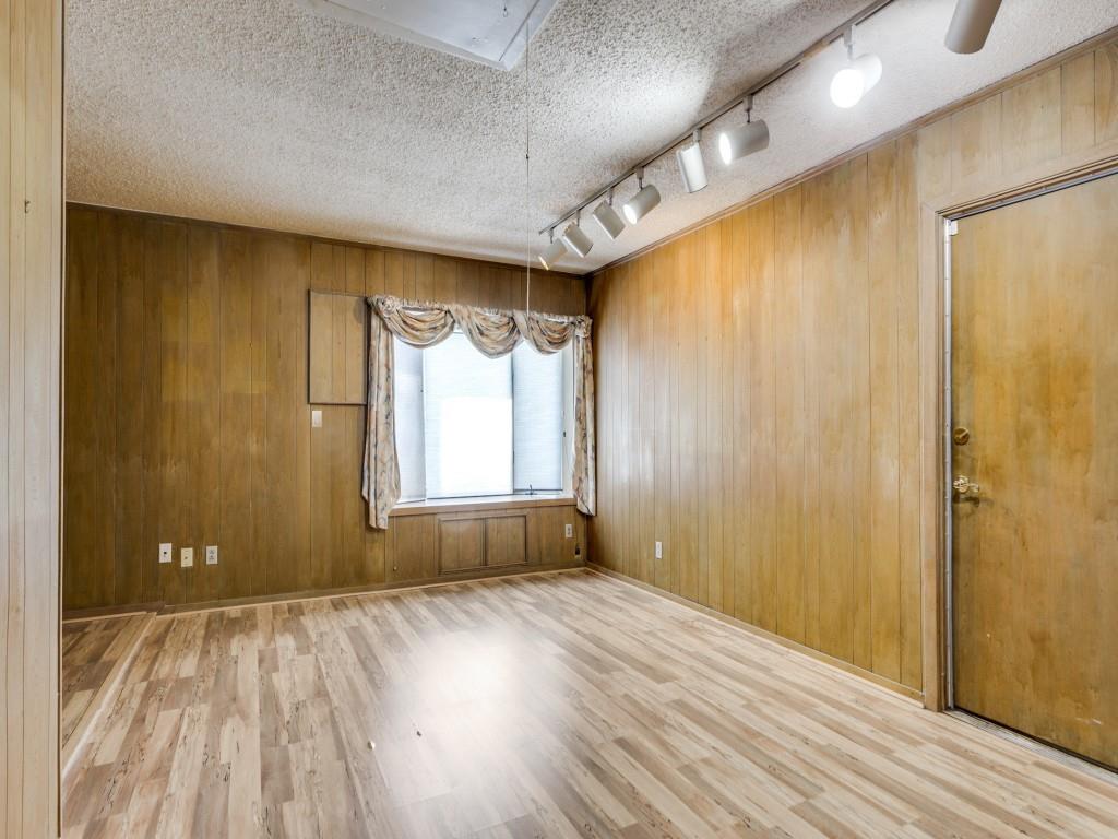 1216 Manning Street Benbrook, TX 76126 - Photo 10 of 26 Spare room with light wood-style flooring, a textured ceiling, wooden walls, and track lighting