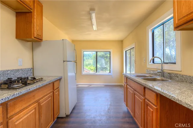 a kitchen with stainless steel appliances granite countertop a stove a sink and a refrigerator