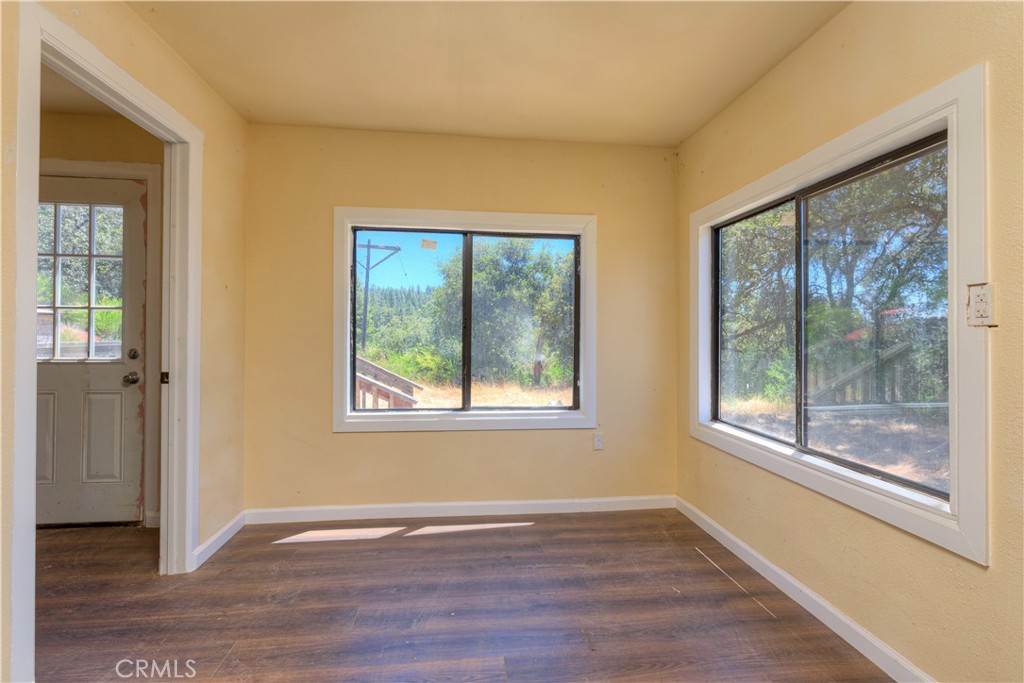 13545 Surcease Mine Road Oroville, CA 95965 - Photo 21 of 28 a view of an empty room with wooden floor and a window