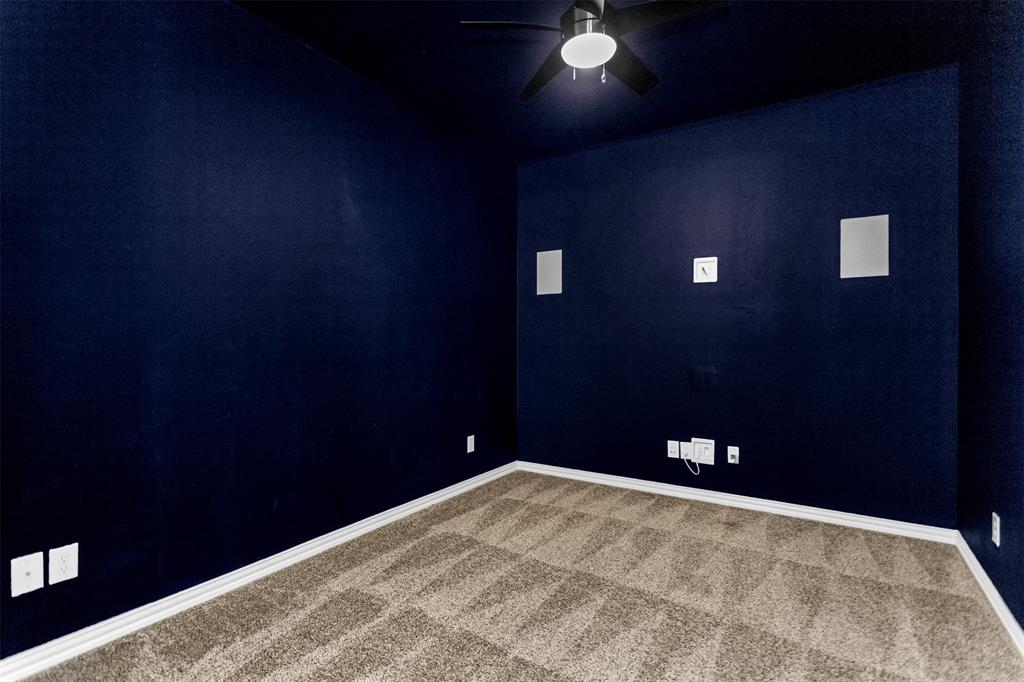 15713 Canyon Ridge Prosper, TX 75078 - Photo 29 of 38 Media room featuring dark blue walls, recessed wall speakers, a ceiling fan with integrated lighting, textured carpeting, and white baseboards
