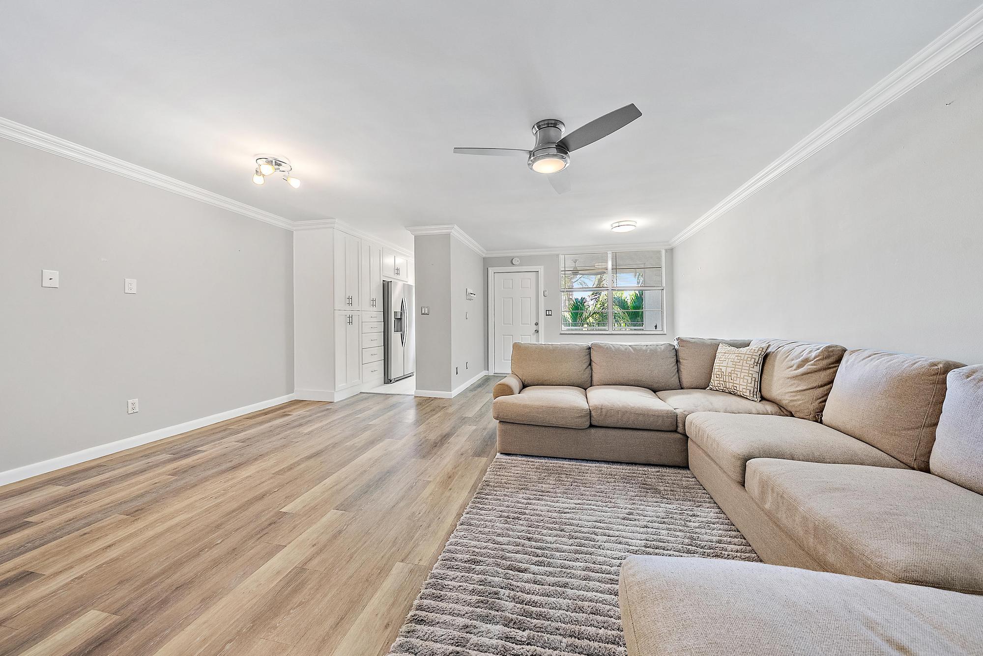 109 Paradise Harbour Boulevard, Unit 307 North Palm Beach, FL 33408 - Photo 1 of 20 a living room with furniture and a ceiling fan