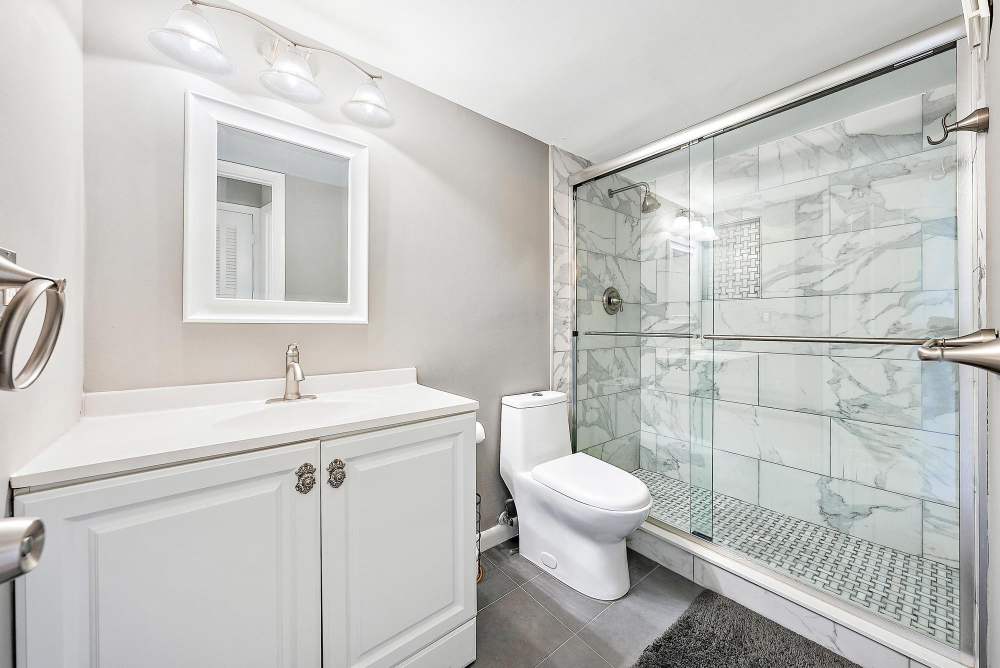 109 Paradise Harbour Boulevard, Unit 307 North Palm Beach, FL 33408 - Photo 12 of 20 a bathroom with a sink toilet and shower