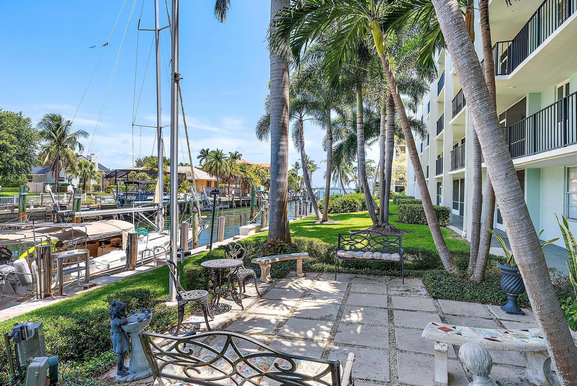 109 Paradise Harbour Boulevard, Unit 307 North Palm Beach, FL 33408 - Photo 18 of 20 a view of a yard with a table and chairs
