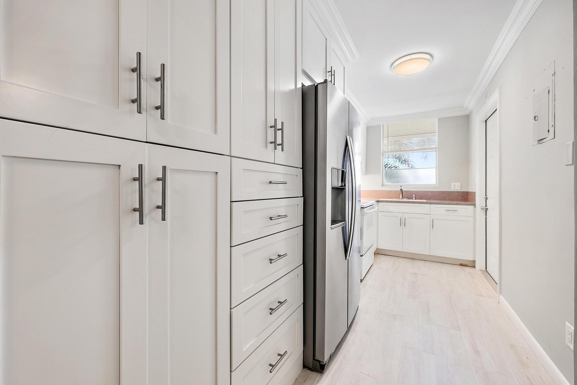 109 Paradise Harbour Boulevard, Unit 307 North Palm Beach, FL 33408 - Photo 3 of 20 a bathroom with a shower sink and mirror