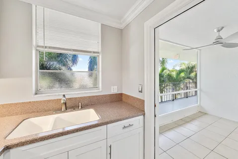a bathroom with a granite countertop sink mirror and window