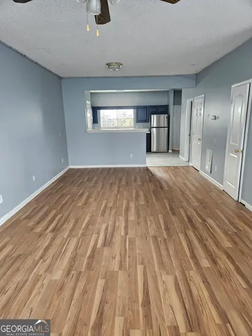 a view of empty room with wooden floor and window