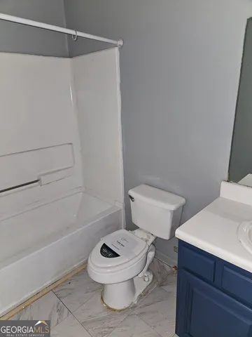 a white toilet sitting next to a bath tub