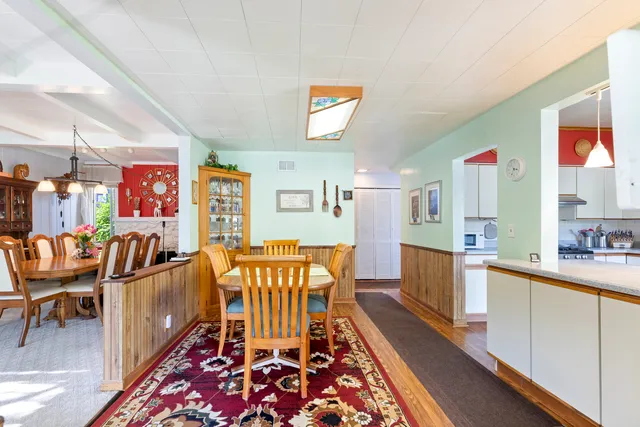 a view of a dining room with furniture a kitchen and chandelier