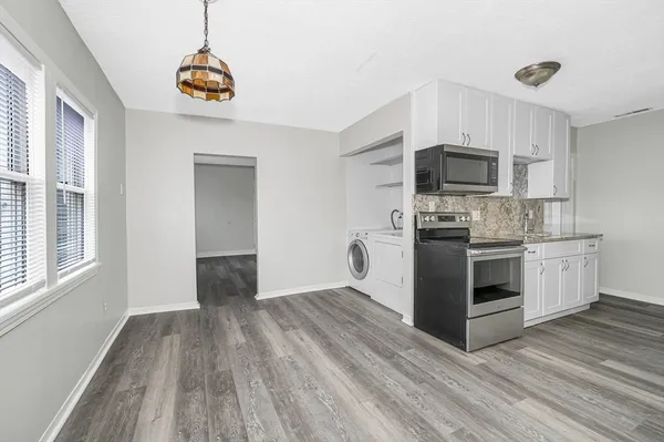 a kitchen with kitchen island granite countertop a sink cabinets and stainless steel appliances