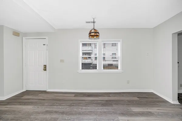 a view of a room with wooden floors and ceiling fan
