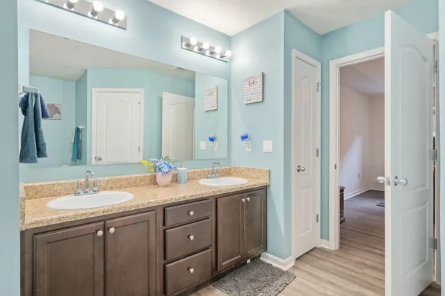 a bathroom with a double vanity sink and mirror with shower