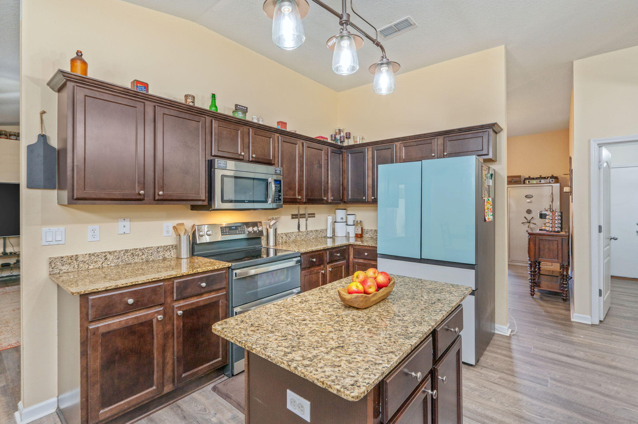 2613 Corner Creek Road Crestview, FL 32536 - Photo 6 of 22 a kitchen with stainless steel appliances granite countertop a kitchen island a stove a refrigerator a sink dishwasher a dining table and chairs with wooden floor