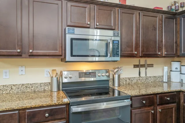 a kitchen with granite countertop a stove and cabinets