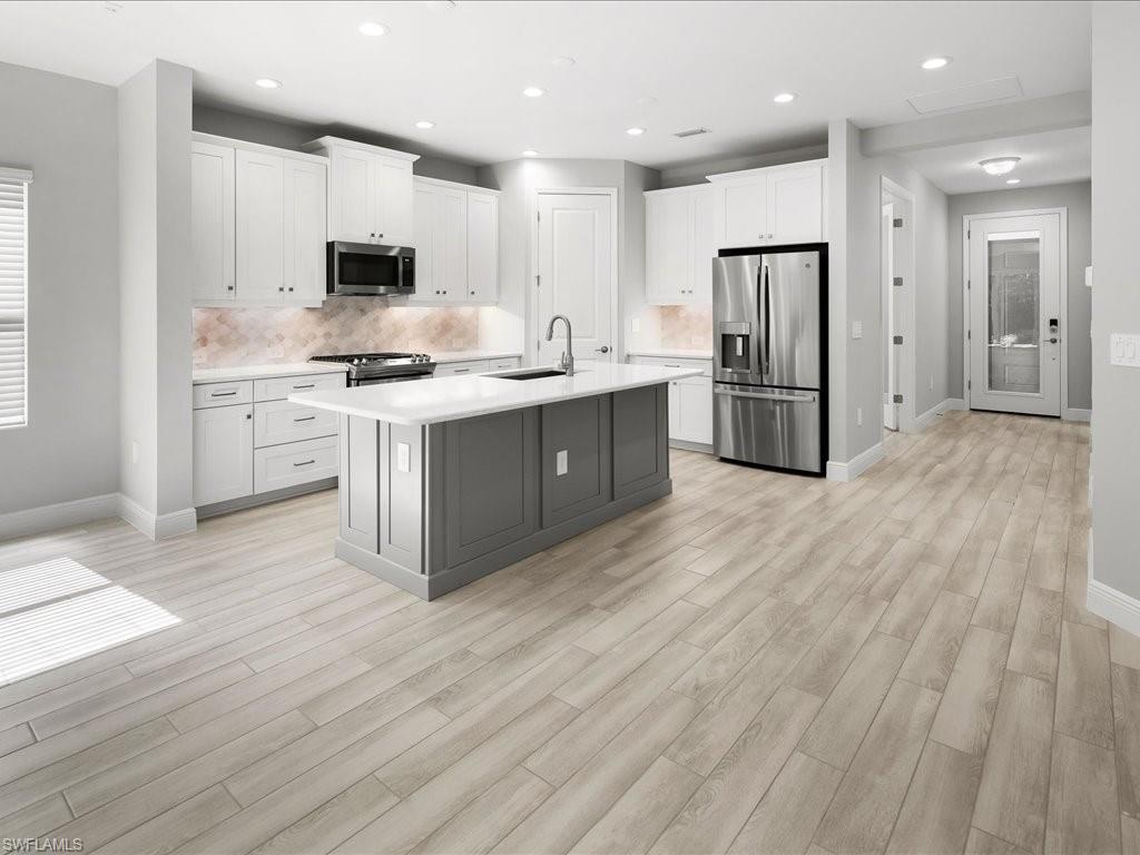 2119 Marquesa Circle Naples, FL 34112 - Photo 11 of 44 a kitchen with a sink cabinets stainless steel appliances and wooden floor
