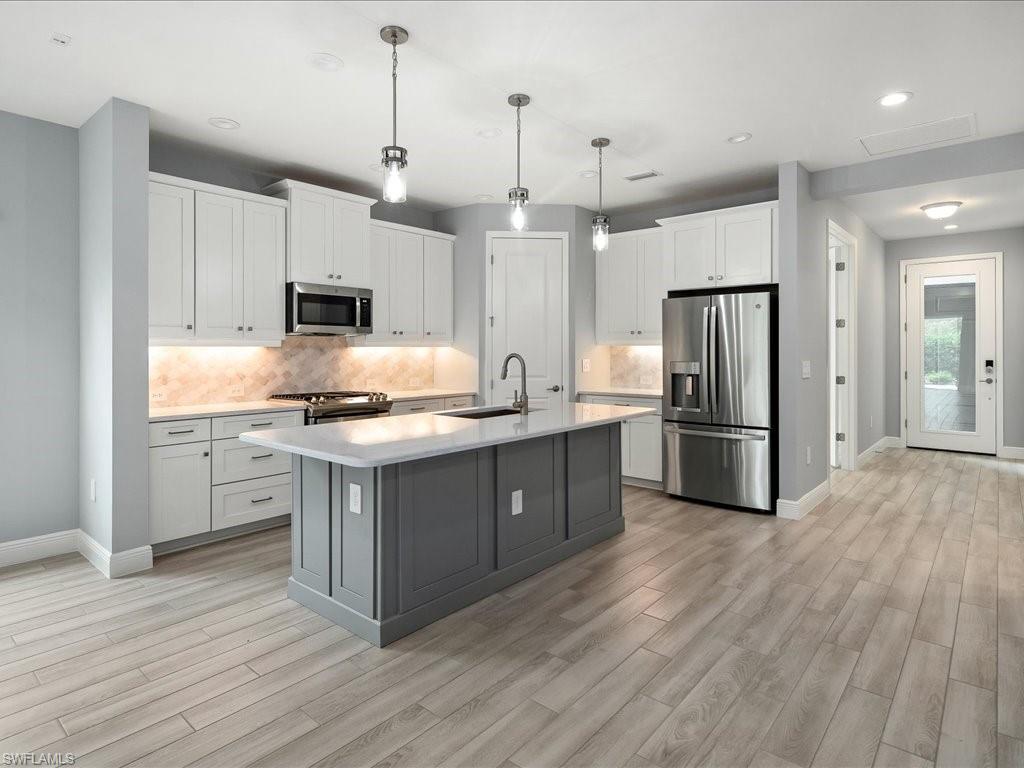 2119 Marquesa Circle Naples, FL 34112 - Photo 2 of 44 a kitchen with kitchen island white cabinets and stainless steel appliances