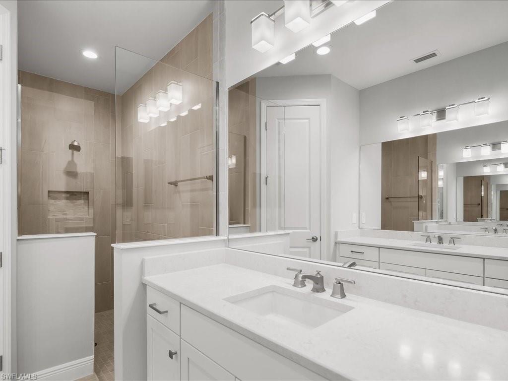 2119 Marquesa Circle Naples, FL 34112 - Photo 24 of 44 a bathroom with a sink a large mirror and a shower