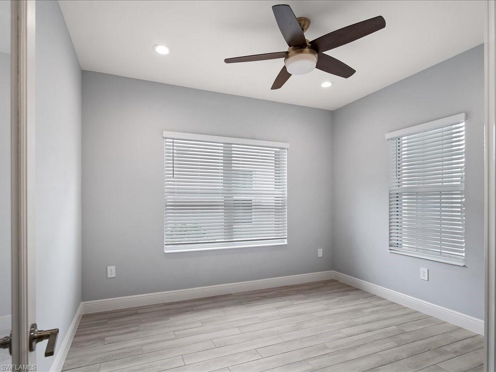 2119 Marquesa Circle Naples, FL 34112 - Photo 29 of 44 a view of an empty room with wooden floor and a window