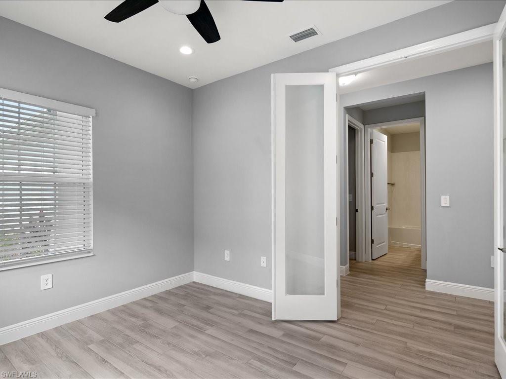 2119 Marquesa Circle Naples, FL 34112 - Photo 30 of 44 wooden floor in an empty room with a window