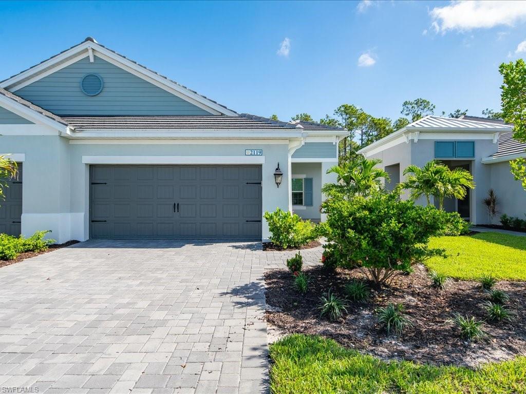 2119 Marquesa Circle Naples, FL 34112 - Photo 3 of 44 a front view of a house with a yard and garage