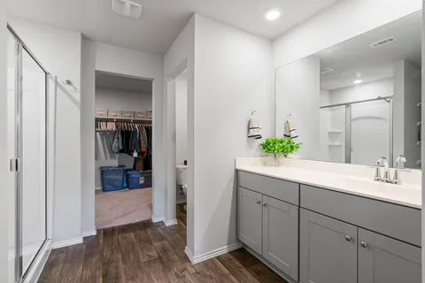 a bathroom with a tub shower vanity and sink