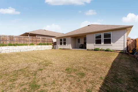 a house with yard and wooden fence