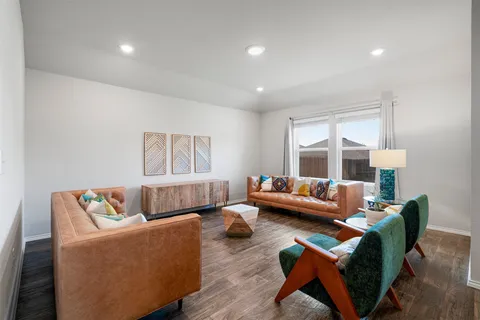 a living room with furniture and a wooden floor