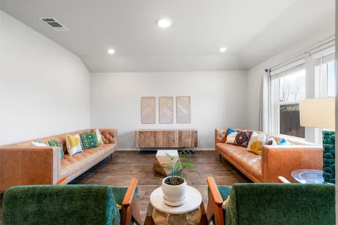 a living room with furniture and a wooden floor