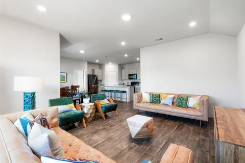 a living room with furniture a kitchen view and a fireplace