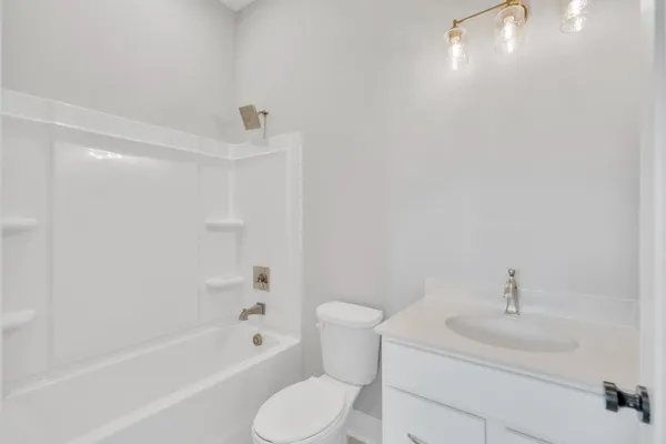 a bathroom with a bathtub shower sink vanity and toilet