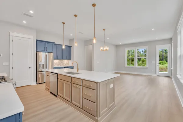 a kitchen with a sink a center island a wooden floor and a window