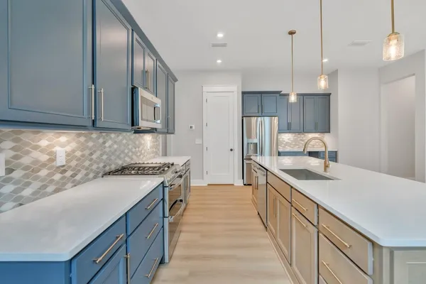 a kitchen with stainless steel appliances granite countertop a sink a stove and a refrigerator