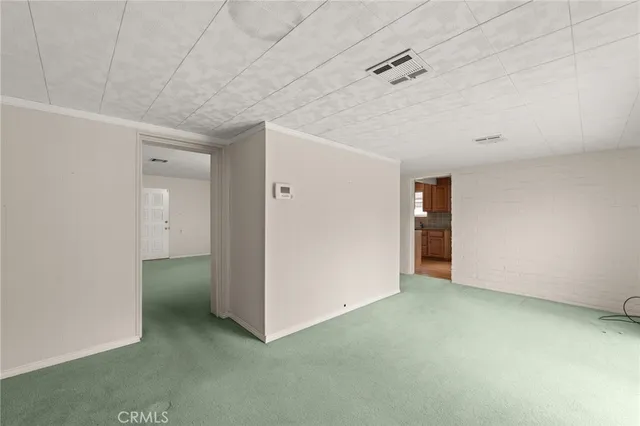 an empty room with wooden floor chandelier fan and windows