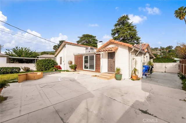 a view of a patio with a table and chairs under an umbrella