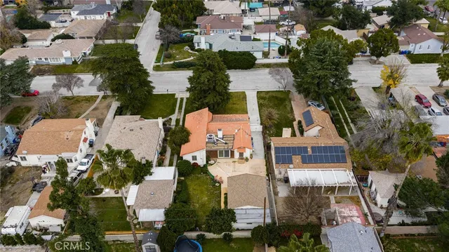 an aerial view of a house with a yard and parking spaces