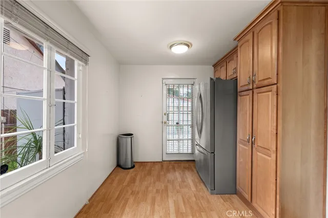 a kitchen with stainless steel appliances granite countertop a stove a sink dishwasher and a refrigerator with wooden floor