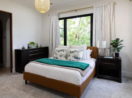 a bedroom with a bed and a potted plant