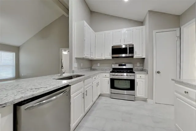 a kitchen with granite countertop a stove and a sink