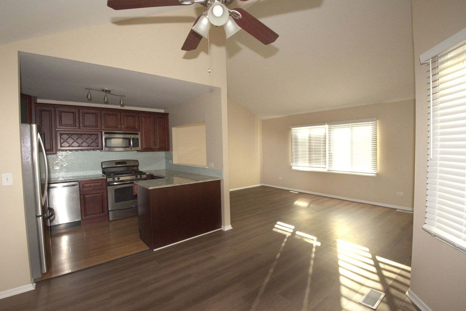 1045 Spring Mill Drive Hoffman Estates, IL 60169 - Photo 3 of 14 a kitchen with stainless steel appliances granite countertop a stove a refrigerator and a sink with wooden floor