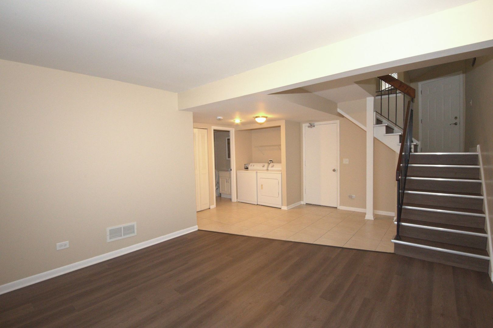 1045 Spring Mill Drive Hoffman Estates, IL 60169 - Photo 10 of 14 a view of an empty room with wooden floor and stairs