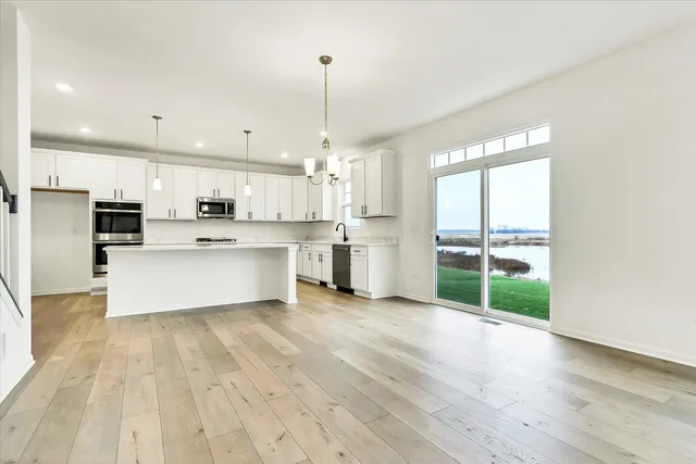 a large white kitchen with wooden floors and white cabinets