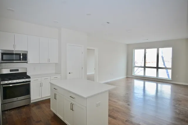a kitchen with a white cabinets and wooden floor