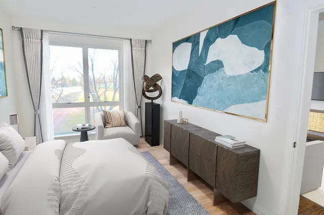 a bedroom with a bed a window and dresser