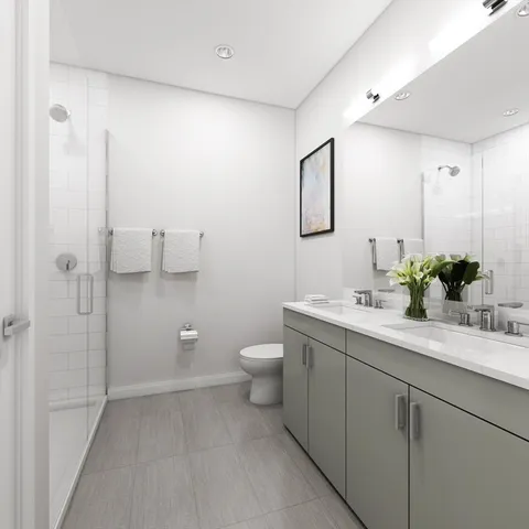 a bathroom with a double vanity sink toilet and shower